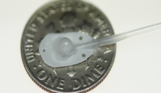 *Photo: Therepi’s reservoir, which would attach directly to the damaged heart tissue, is placed on a dime for size reference and connected to a self-sealing subcutaneous port by Whyte, et al./Nature Biomedical Engineering